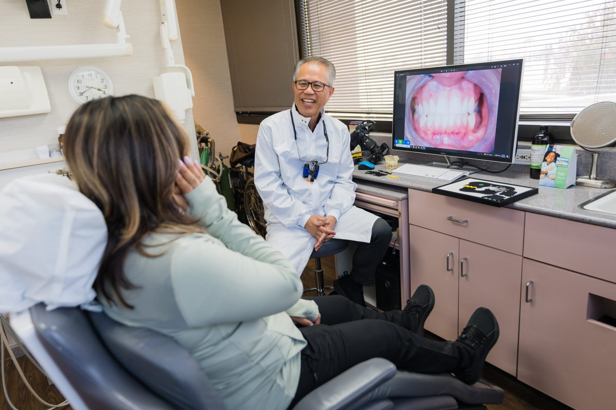 Dr. Peter Young talks a patient through her photos on screen — Premier Dental Esthetics, Arcadia